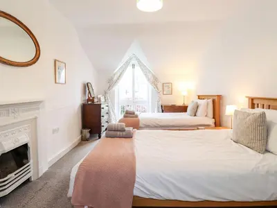 two beds in a room with a fireplace at Middletown in Keswick
