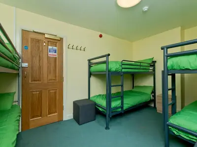 a room with three bunk beds and a door at YHA Ennerdale in Buttermere