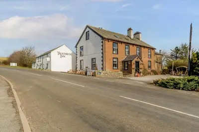 a building on the side of a road next to a street at Troutbeck Inn Cottages in Troutbeck