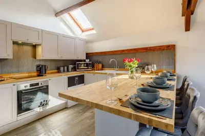 a kitchen with a table with plates and wine glasses at Troutbeck Inn Cottages in Troutbeck