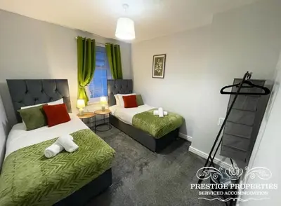 a bedroom with two beds with green sheets and a window at Jackson St by Prestige Properties SA in Siddick