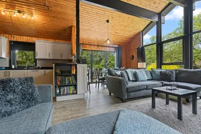 a living room with two couches and a kitchen at Newsham Lodge in Ellonby