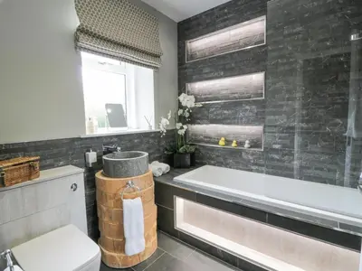 a bathroom with a bath tub and a toilet at Waterside Lodge in Lockerbie