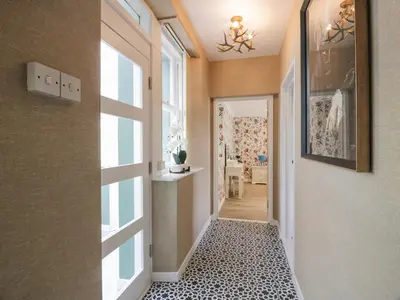 a hallway with a door and a tile floor at Waterside Lodge in Lockerbie