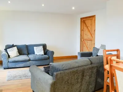a living room with two blue couches and a door at Meadow Lodge-E4105 in Aspatria