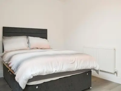 a bedroom with a large bed with white walls at Sunset View-E4107A in Aspatria