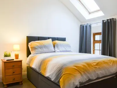 a bedroom with a bed with a black and yellow comforter at Sunset View-E4107A in Aspatria