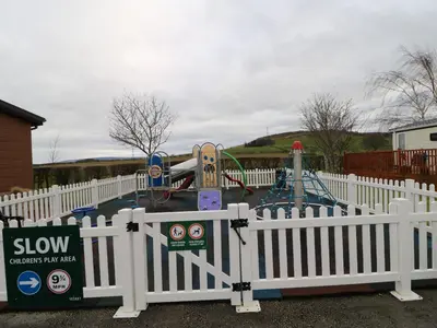 a white fence in front of a playground at Brocklebank Lodge, 35 in Carlisle