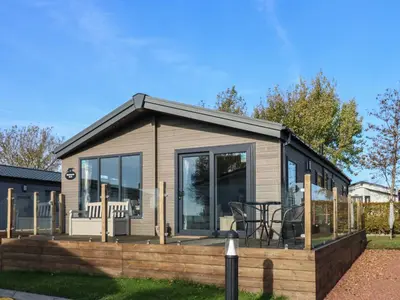 a tiny house with a deck with a table at Brocklebank Lodge, 35 in Carlisle