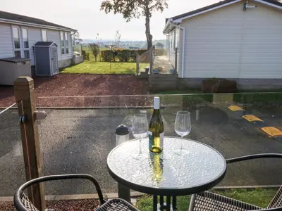 a bottle of wine sitting on a table with two glasses at Brocklebank Lodge, 35 in Carlisle