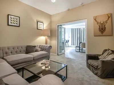 a living room with a couch and a table at The Loans Inn Cottage in Loans