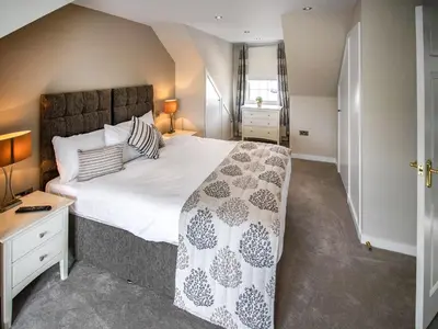 a bedroom with a large bed and a desk at The Loans Inn Cottage in Loans