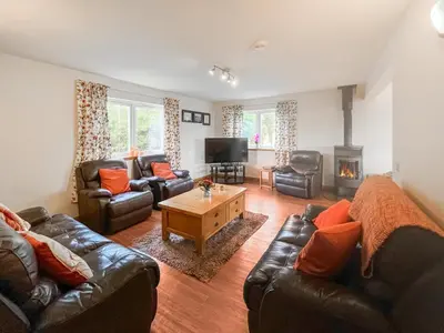 a living room with leather furniture and a fireplace at Quare Place in Mainsriddle