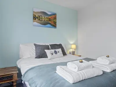 a bedroom with a bed with towels on it at Finest Retreats - Willow Dene in Cockermouth