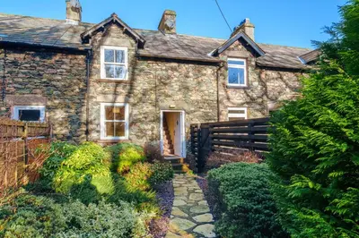 an old stone house with a garden in front of it at 7 Low Glenridding - with private parking in Glenridding