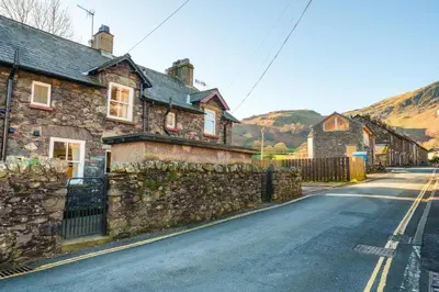 a stone house on the side of a street at 7 Low Glenridding - with private parking in Glenridding