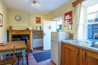 a kitchen with a table and a sink and a refrigerator at 7 Low Glenridding - with private parking in Glenridding
