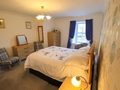 a bedroom with a bed and a dresser and a window at Lakeland View Lodge in Keswick