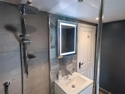 a bathroom with a sink and a shower with a mirror at Lakeland View Lodge in Keswick