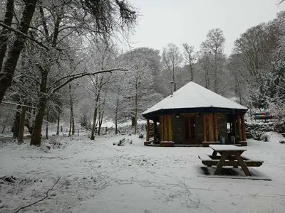 a wooden cabin with a picnic table in the snow at The Dairy - Patterdale Hall in Penrith