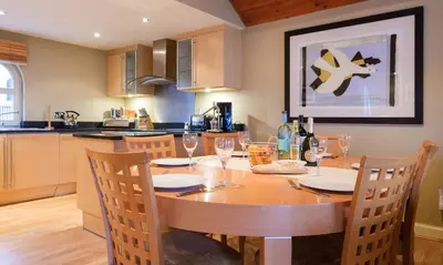 a kitchen with a wooden table with wine glasses on it at Blencathra in Keswick