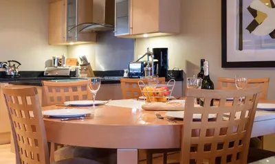 a wooden table with chairs and wine glasses on it at Blencathra in Keswick
