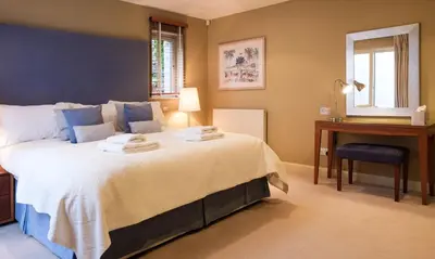 a bedroom with a bed and a desk and a window at Blencathra in Keswick