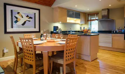 a kitchen with a wooden table with chairs and a dining room at Underscar - Stonethwaite in Keswick