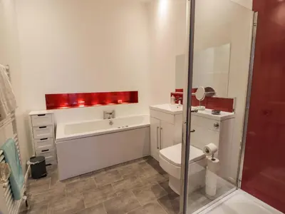 a bathroom with a tub and a toilet and a sink at Ailsa View in Girvan