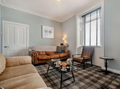 a living room with a couch and a table at 2 Bed seafront cottage in Portpatrick in Portpatrick
