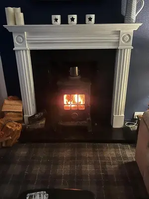 a fireplace with a fire inside of it at 2 Bed seafront cottage in Portpatrick in Portpatrick