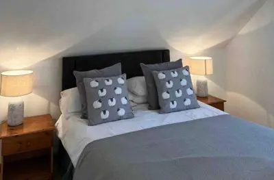 a bedroom with a bed with pillows and two lamps at Maiden Moor in Borrowdale Valley
