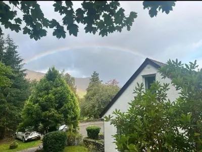 a rainbow in the sky over a house at Maiden Moor in Borrowdale Valley