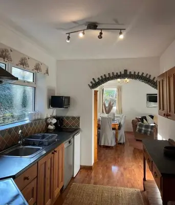 a kitchen with a sink and a living room at Maiden Moor in Borrowdale Valley