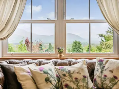 a couch with pillows in front of a window at 3 Bed in Keswick oc-sz080 in Braithwaite
