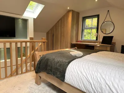 a bedroom with a bed and a flat screen tv at Field Apartment in Douglas