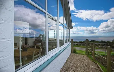 a view of the ocean from the balcony of a house at Bardristane Forge in Gatehouse of Fleet