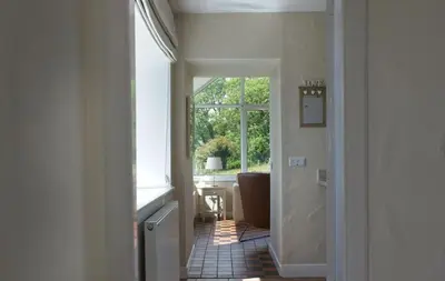 a hallway with a bathroom with a window at Bardristane Forge in Gatehouse of Fleet