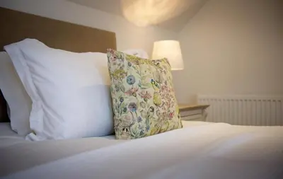 a white bed with a pillow on top of it at Curlew Cottage in Gatehouse of Fleet