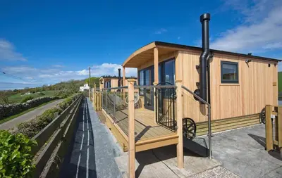 a modular house with a deck on a street at Little Beach in Gatehouse of Fleet
