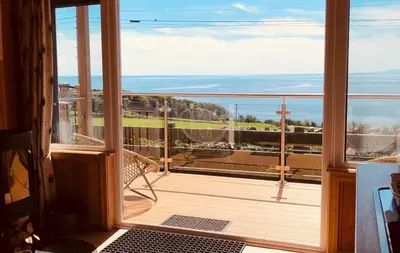 a balcony with a view of the ocean at Little Oak in Gatehouse of Fleet