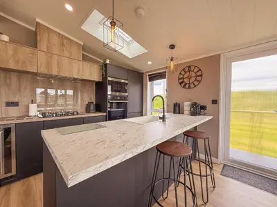 a kitchen with a large counter top and stools at Dogwood Lodge in Bassenthwaite