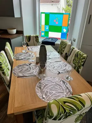 a wooden table with wine glasses on top of it at Kennedy Cottage by Troon beach in Troon