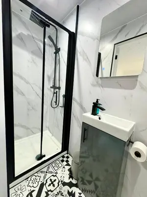 a white bathroom with a shower and a sink at Kennedy Cottage by Troon beach in Troon