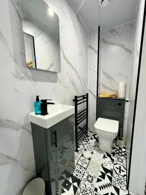 a white bathroom with a sink and a toilet at Kennedy Cottage by Troon beach in Troon