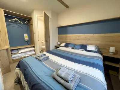 a bedroom with a large bed with towels on it at Cosy 3BR Getaway in Beautiful Country Park - Pass the Keys in Beattock