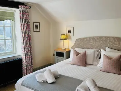 a bedroom with a large bed with a window at Stone Arthur Cottage in Ambleside