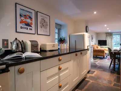 a kitchen with a counter and a refrigerator at Stone Arthur Cottage in Ambleside