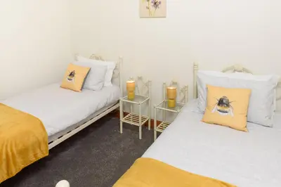 two twin beds in a room with two candles at Shell Cottage in Whithorn