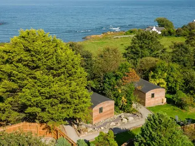 an aerial view of a house with the ocean in the background at Rowan in Whithorn